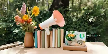 Estantería con un libro, una lupa y el logo de BiossFera Terra